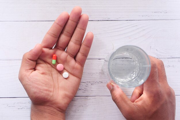 Close up of man hand taking medicine .