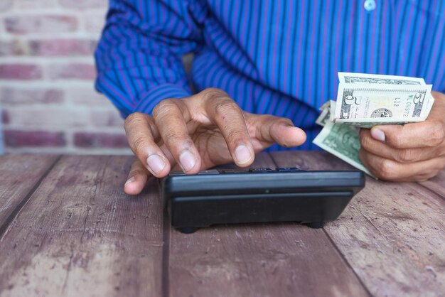 Photo close up of man hand using calculator