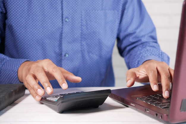 Close up of man hand using calculator