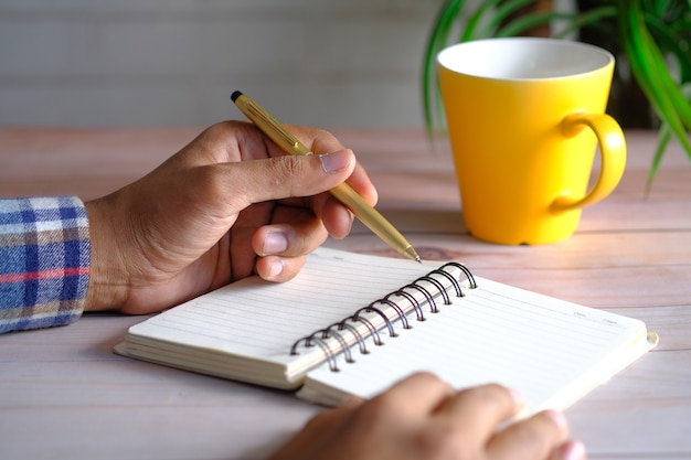 Close up of man hand writing on notepad