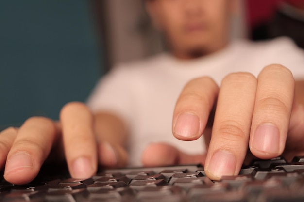 キーボードでタイピングする男性の手指のクローズアップ