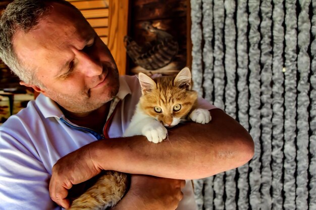 Photo close-up of man holding cat at home