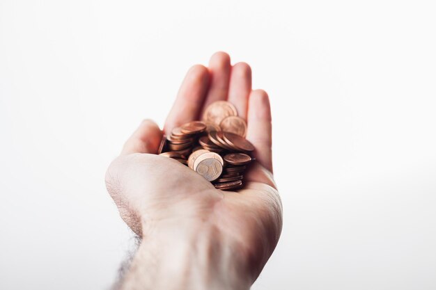 Photo close-up of man holding coins over white background