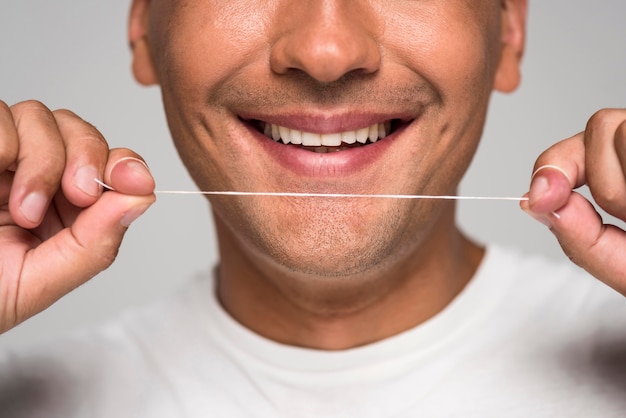 Foto uomo del primo piano che tiene filo interdentale