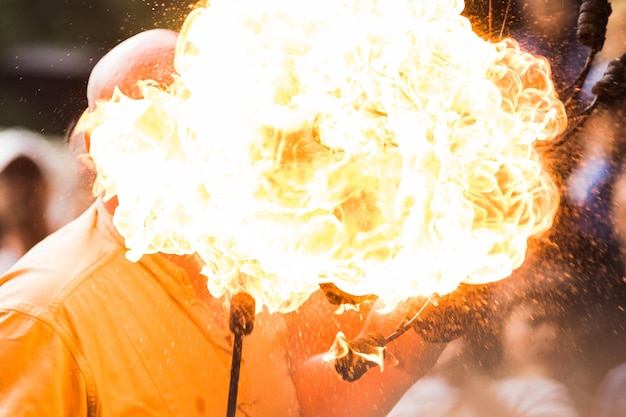 Photo close-up of man holding fire against blurred background