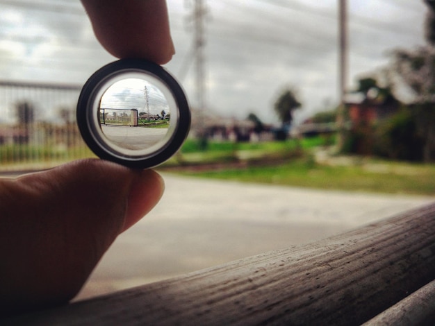 Foto close-up di un uomo che tiene un vetro contro il cielo