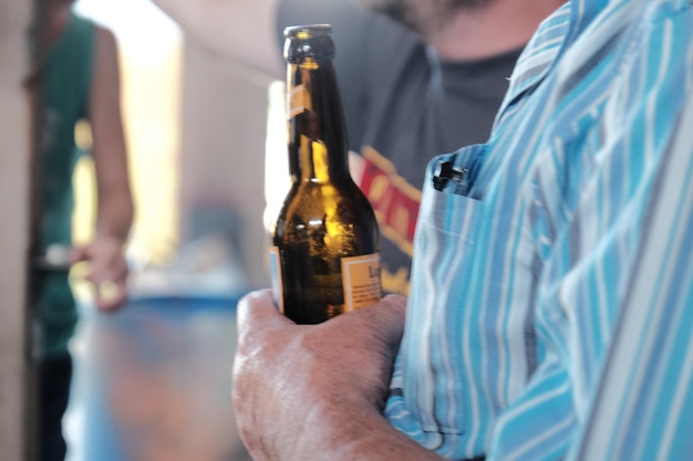 Close-up of man holding glass bottle