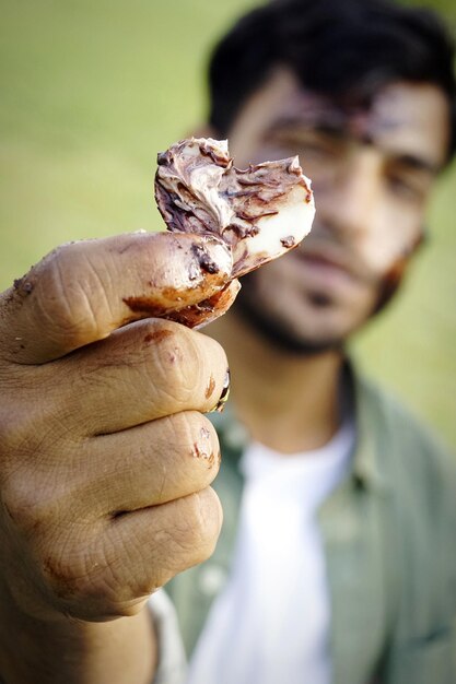 Photo close-up of man holding heart shape sweet food