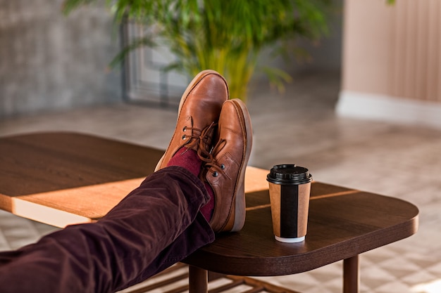 Close up of a man holding his legs on a table