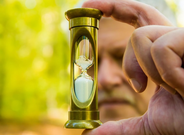 Close-up of man holding hourglass