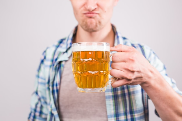 Primo piano di un uomo che tiene in mano un boccale di birra. sfondo con copia spazio.