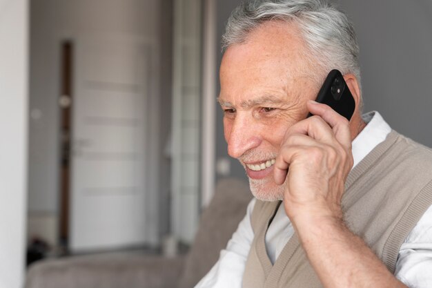 Primo piano uomo che tiene il telefono