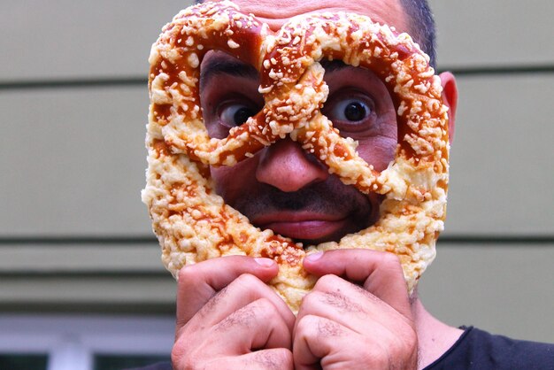 Foto close-up di un uomo che tiene un pretzel