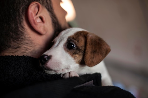 Photo close-up of man holding puppy at home