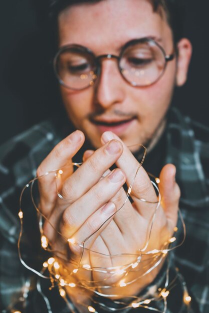 Foto close-up di un uomo che tiene in mano una luce a corda