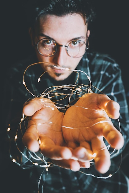 Foto close-up di un uomo che tiene in mano una luce a corda