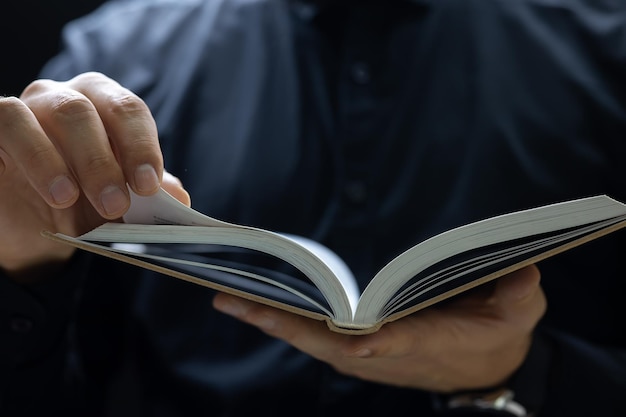 Close-up man holding the tip of a sheet to the book he wants