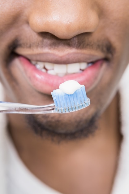 Primo piano di un uomo che tiene spazzolino da denti