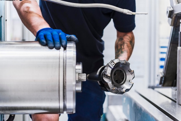 Close-up of man holding workpiece in industrial factory