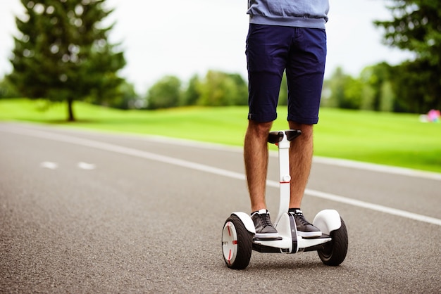 Avvicinamento. un uomo sta guidando attraverso il parco su un giroscopio.