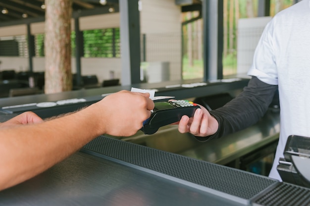 Primo piano un uomo sta pagando con carta di credito attraverso il terminale.