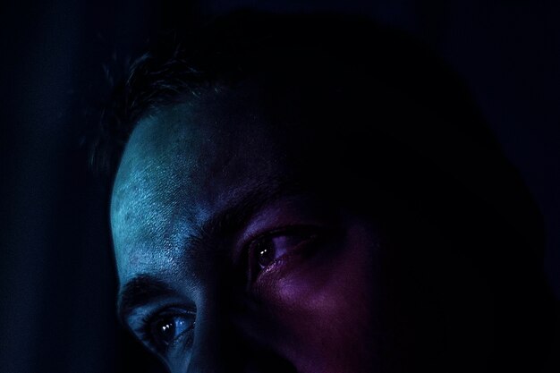 Photo close-up of man looking away against black background