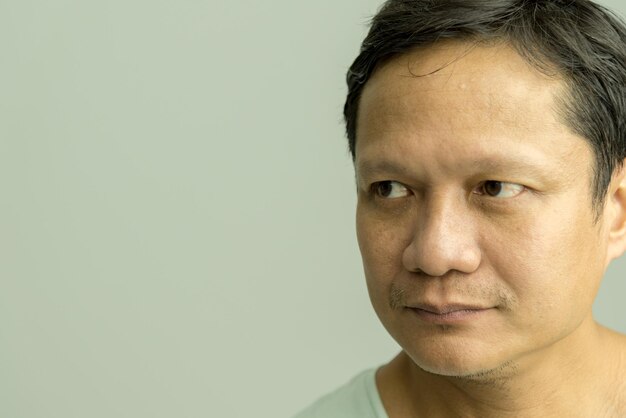 Close-up of man looking away against gray background