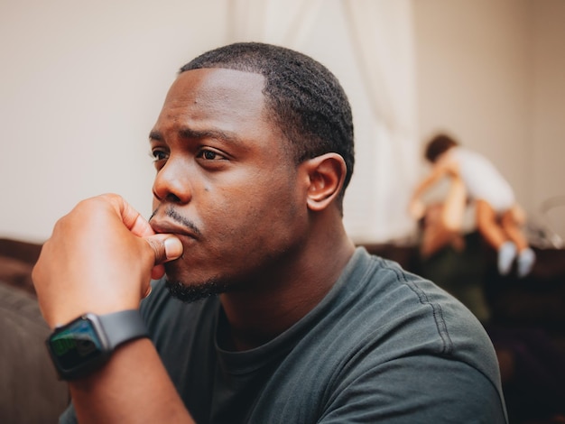 close-up of man looking away while sitting at home