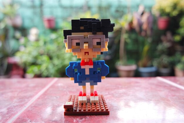 Photo close-up of man made with toy blocks on tile