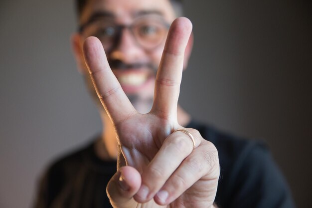 Foto close up dell'uomo che fa il segno della vittoria con le mani concetto di successo