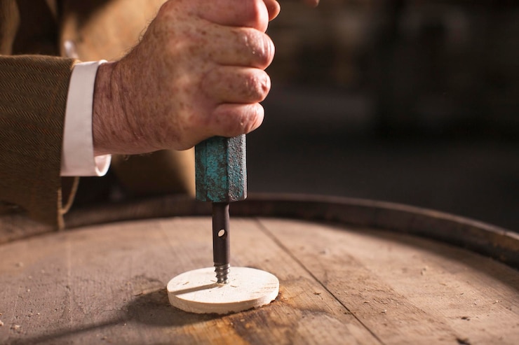 Photo close-up of man opening whiskey barrel
