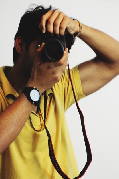 Close-up of man photographing against white background