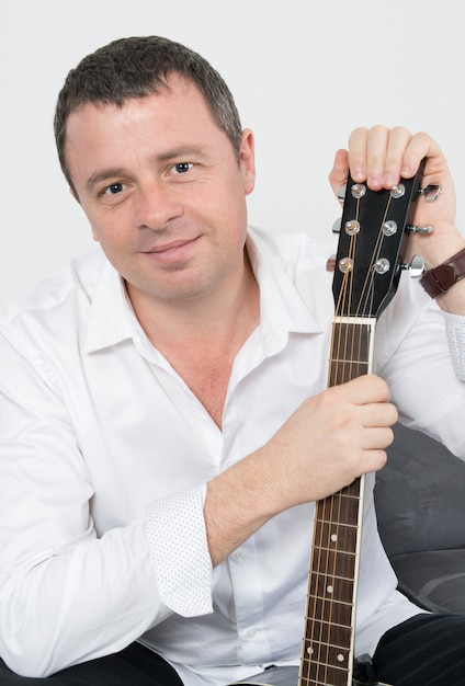 Close up on a man playing guitar at home