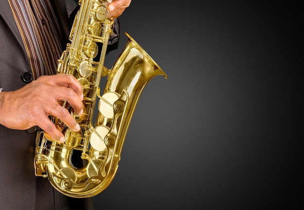 Close-up man playing on saxophone on  background