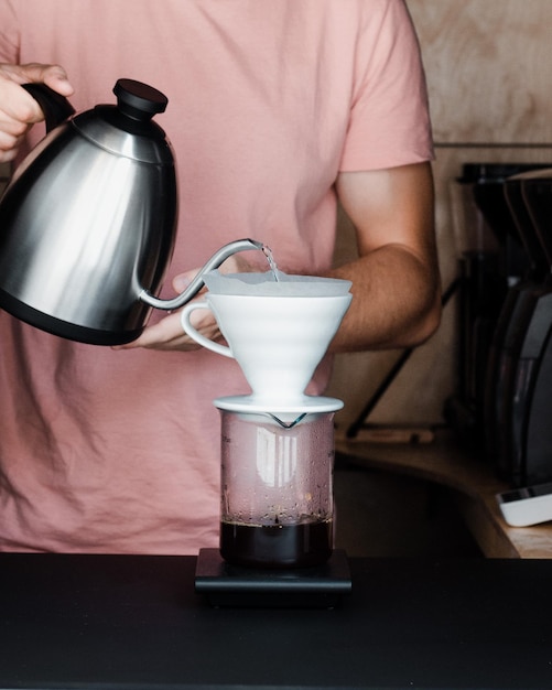 Foto close-up di un uomo che versa il caffè in una tazza