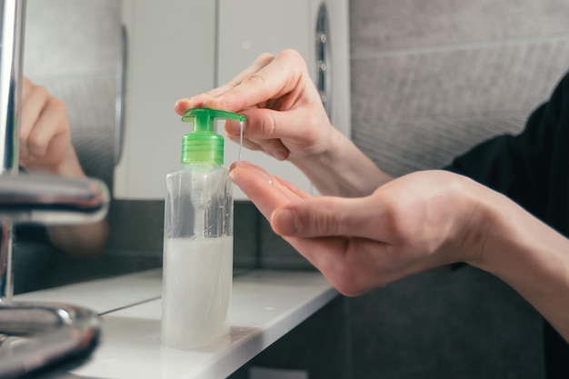 Close up man pressing the dispenser with bactericidal soap