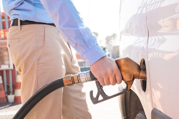 Close up man pumping gas car refueling on petrol station