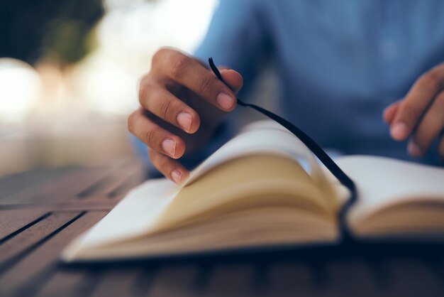 Foto close-up di un uomo che legge un libro sul tavolo