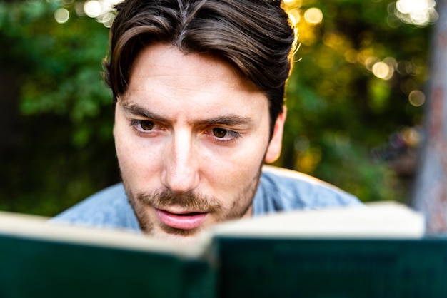 Foto close-up di un uomo che legge un libro