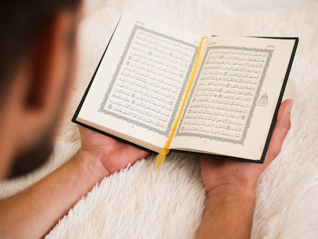 Photo close up of man reading from quran