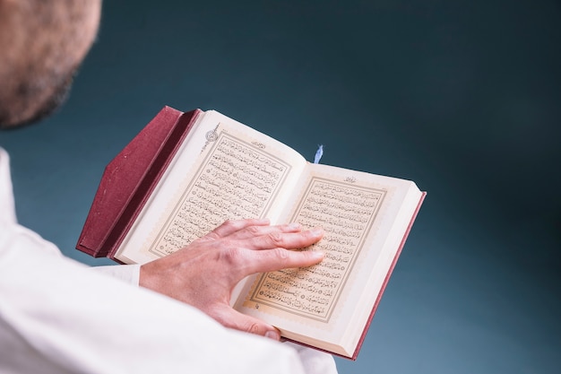 Photo close up of man reading in quran