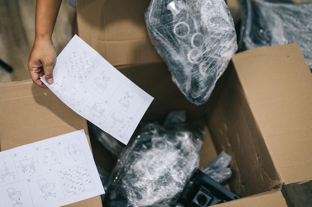 Close up of man received package and unpacking cardboard box