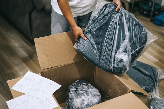 Close up of man received package and unpacking cardboard box