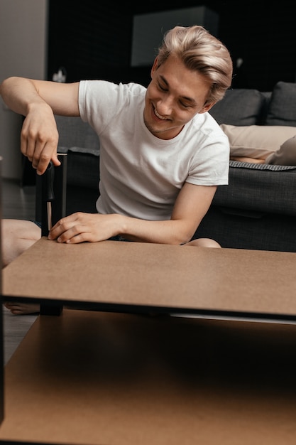 Close up on man repairing a table indoors