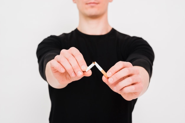 Close-up of man's hand breaking cigarette