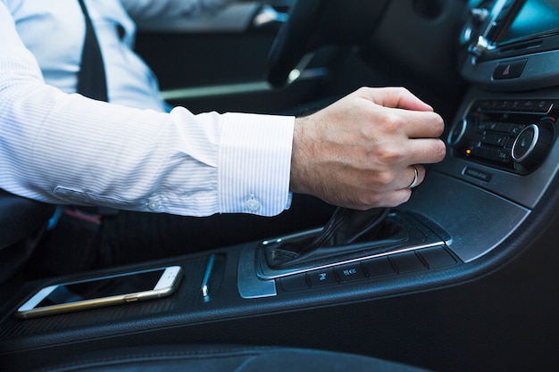 Close-up of a man's hand changing gear in car