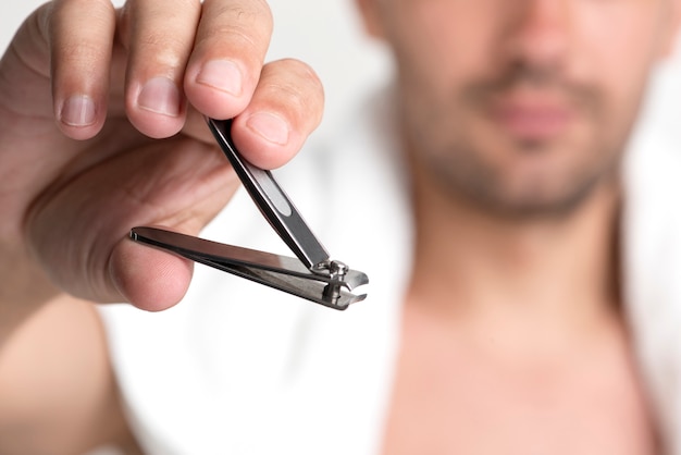 Photo close-up of man's hand holding nail clipper