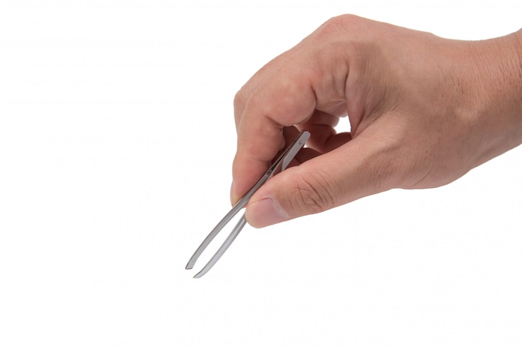 Photo close up of man's hand holding an tweezers.