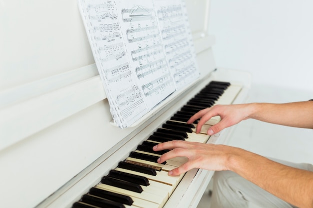 Foto primo piano della mano dell'uomo che suona il pianoforte