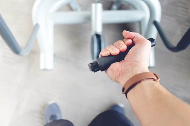 Close up of man's hand pull cable weight in a fitness gym.